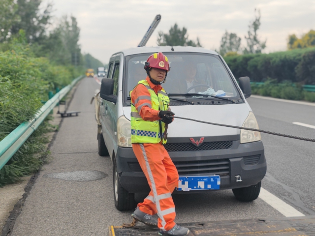 亳州中心阜陽段上行K376施救員徐建才調(diào)整拖車鋼絲繩，開展救援行動。.jpg